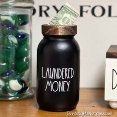 a jar with money sitting on top of a table next to a sign that says launderred money