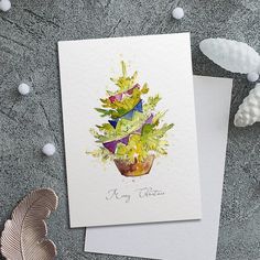 a card with a watercolor painting of a potted plant on top of it