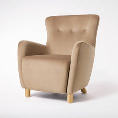 a beige chair sitting on top of a white floor next to a wooden legrest