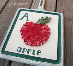 an apple is made out of string on a sign with the letter a in it