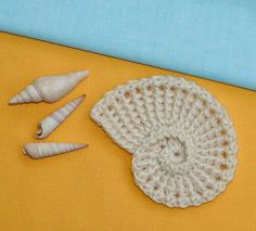 crocheted shells and sea urchins on a yellow surface with blue background