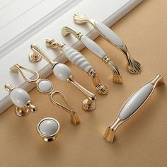 gold and white kitchen utensils are lined up on the floor