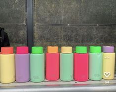 thermos are lined up next to each other in front of a building wall