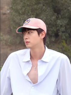 a young man wearing a pink hat and white shirt