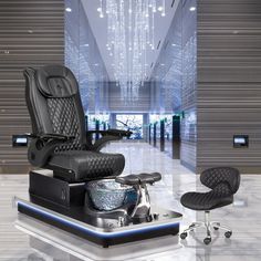 an office chair and foot stool in front of a chandelier