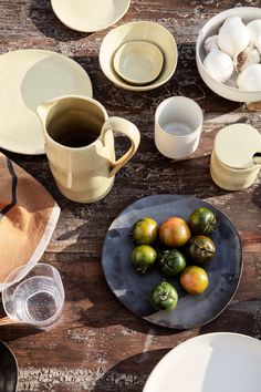 the table is set with plates, cups and bowls on it as well as other dishes