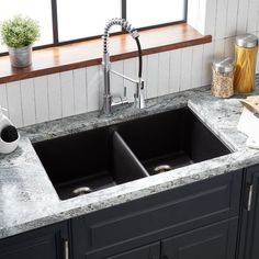 a kitchen sink sitting under a window next to a counter