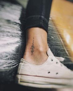 a woman's foot with a small tattoo on her left ankle and the word love written in cursive writing