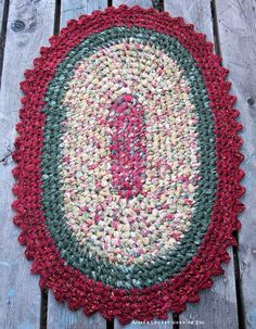 a red and green rug sitting on top of a wooden floor next to a bench