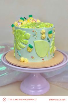 a cake decorated with pineapples and other decorations on a plate in front of a white background