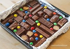 a pan filled with chocolate candy on top of a wooden table