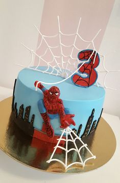 a spiderman themed cake on a gold plate