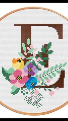 a cross stitch pattern with the letter d and flowers