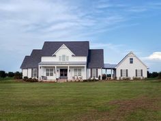 a large white house sitting on top of a lush green field