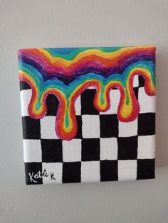 a colorful painting on a white wall with black and white checkerboard pattern in the background