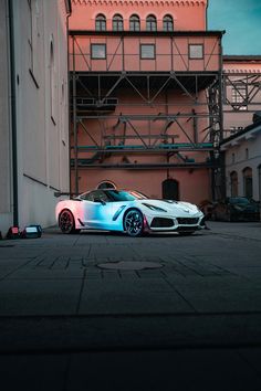 a white sports car parked in front of a building