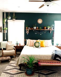 a bed room with a neatly made bed next to a window and a ceiling fan