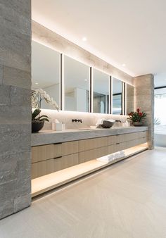 a large bathroom with two sinks and mirrors on the wall next to eachother