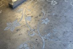 the floor is decorated with white flowers and leaves in an intricate pattern on it's surface