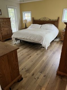 a bed sitting in the middle of a bedroom on top of a hard wood floor