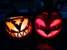 two carved pumpkins sitting on top of a table