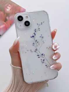 a woman holding an iphone case with flowers on it