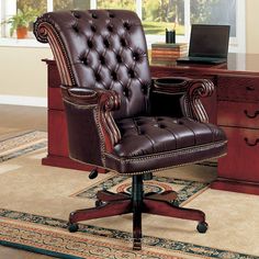 a brown leather office chair sitting in front of a desk with a laptop on it