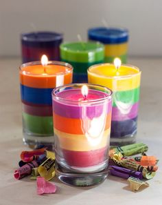 there are many different colored candles on the table