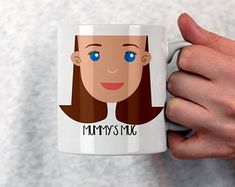 a person is holding a coffee mug with a face on it that says, mommy