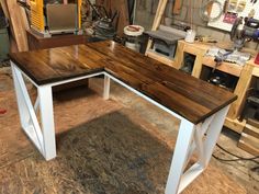 a wooden desk sitting on top of a hard wood floor in a room filled with tools