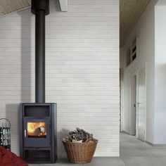 a wood burning stove sitting next to a basket filled with firewood