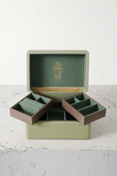 an open box with three compartments on top of a marble counter next to a white wall