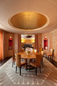 a dining room with a round table surrounded by chairs