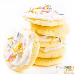 a stack of cookies with white frosting and sprinkles