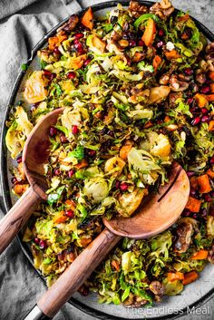 a plate full of chopped vegetables with wooden spoons