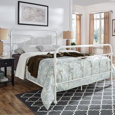 a white metal bed frame in a bedroom