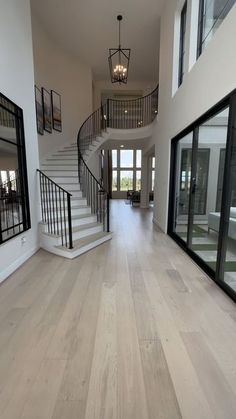 a large open floor plan with stairs leading to the second story and glass doors on both sides