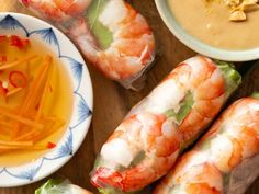 shrimp and vegetable wrapped in paper next to dipping sauce on a plate with chopsticks