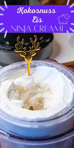 a cup filled with whipped cream and topped with a gold reindeer head sticking out of it