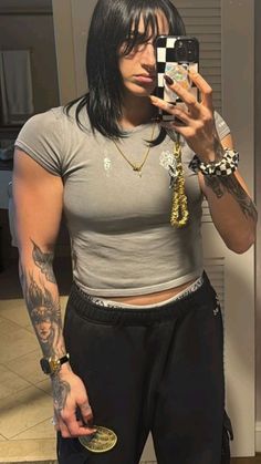 a woman taking a selfie with her cell phone in front of her face and tattoos on her arm