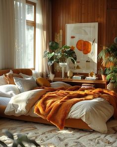 a large bed sitting in a bedroom next to a window filled with potted plants