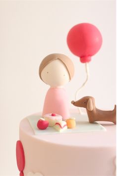 a cake with a dog and balloon on top