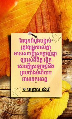 a piece of paper with the words in thai on it next to some autumn leaves