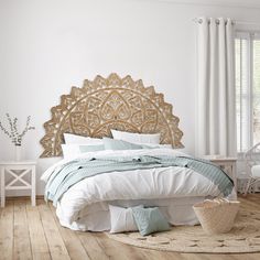 a bedroom with white walls and wood flooring has a large headboard on the wall