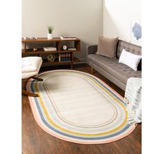 a living room filled with furniture and a rug on top of a hard wood floor