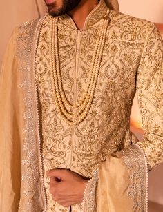 Presenting nawab sherwani in golden color with intricate embroidery scattered all over including beads, thread, sequence, mirror and cutdana work. Reception Sherwani With Intricate Embroidery, Chinon Sherwani With Mirror Work For Festive Occasion, Chinon Sherwani With Dabka Work For Reception, Wedding Sherwani With Intricate Embroidery In Chinon, Dabka Work Chinon Sherwani For Reception, Festive Chinon Sherwani With Intricate Embroidery, Festival Sherwani With Dupatta In Chinon, Festival Chinon Sherwani With Dupatta, Wedding Sherwani With Dabka Work In Chinon