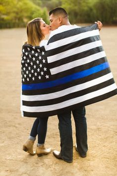 a man and woman are wrapped up in an american flag blanket while kissing each other