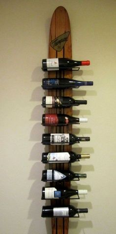 a wine rack with several bottles on it and a surfboard mounted to the wall