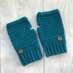 two blue knitted mittens sitting next to each other