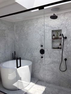 a white bath tub sitting inside of a bathroom next to a walk - in shower